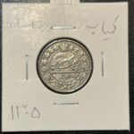 این سکه ۱۰۰ دیناری نیکل، ضرب سال ۱۳۰۵ و متعلق به دوره رضا شاه است که به دلیل سال ضرب خود تاریخ کمیاب محسوب می‌شود و با اصالت ضرب یک برای مجموعه‌داران عرضه می‌گردد.